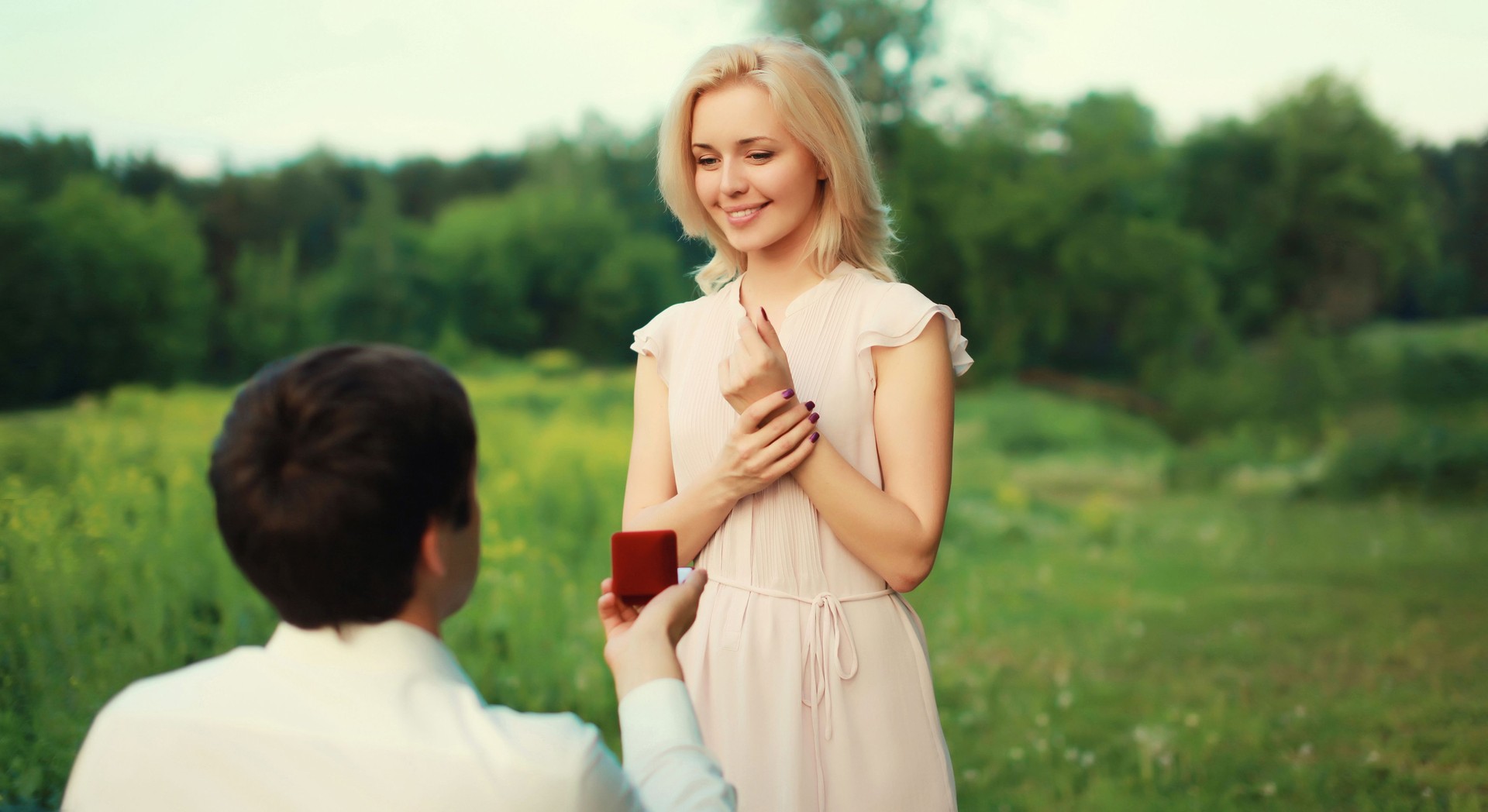 Wedding happy lovely young couple, man proposing a ring to his beloved woman outdoors in summer park